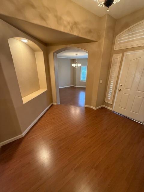 foyer entrance featuring dark hardwood / wood-style flooring and a notable chandelier