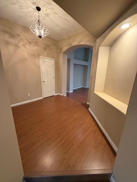 interior space with dark wood-type flooring and an inviting chandelier