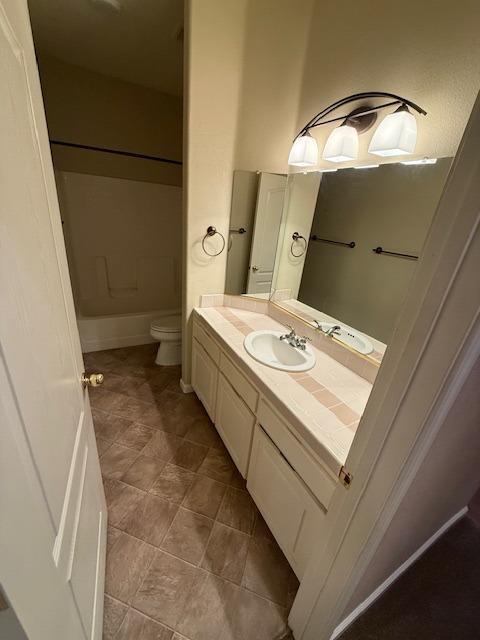 full bathroom with tile patterned flooring, vanity, toilet, and shower / washtub combination