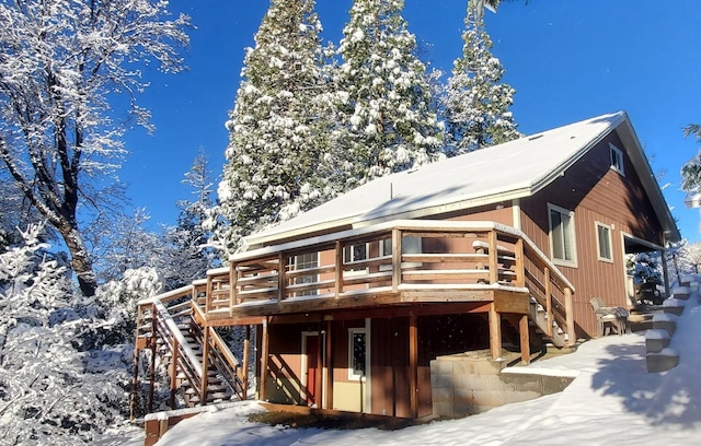 snow covered property with a wooden deck