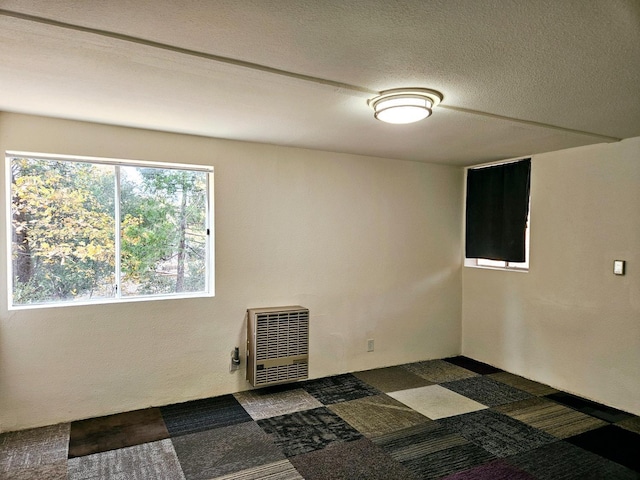 spare room featuring a textured ceiling and heating unit