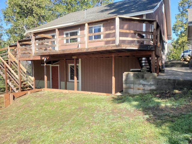 rear view of property with a wooden deck and a lawn