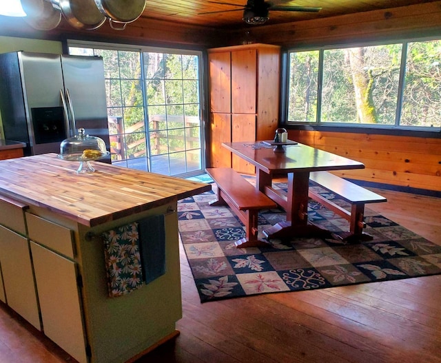 interior space featuring ceiling fan, wood-type flooring, wood walls, and wood ceiling