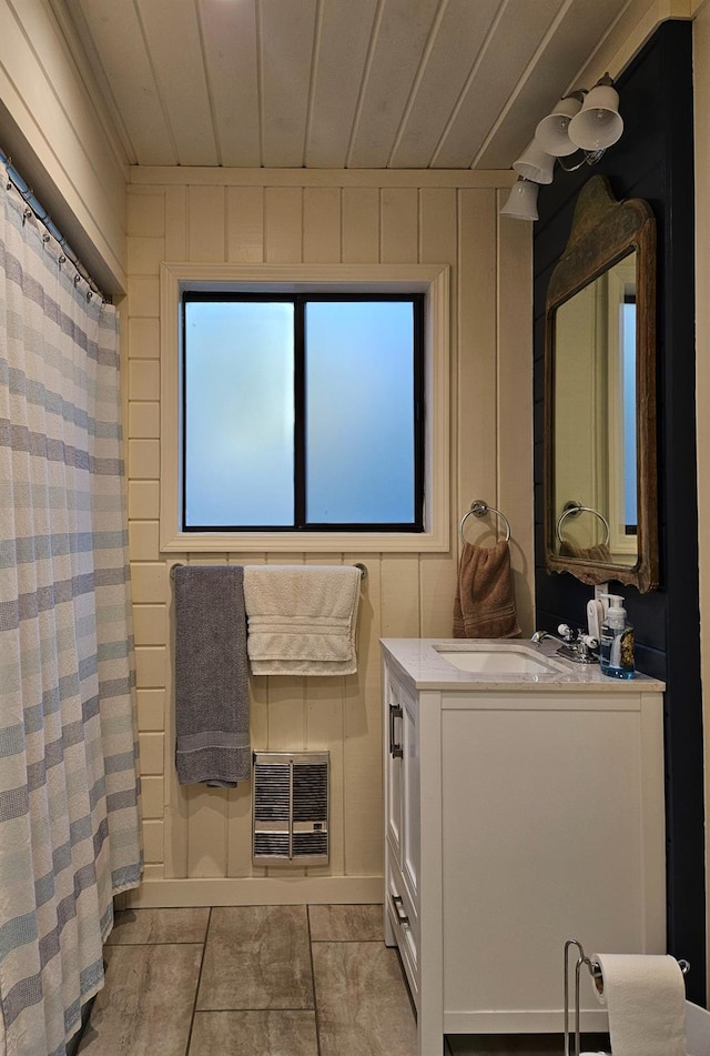 bathroom with tile patterned flooring, wood ceiling, wood walls, and vanity