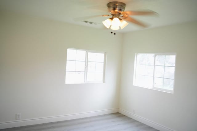 spare room with ceiling fan and light wood-type flooring