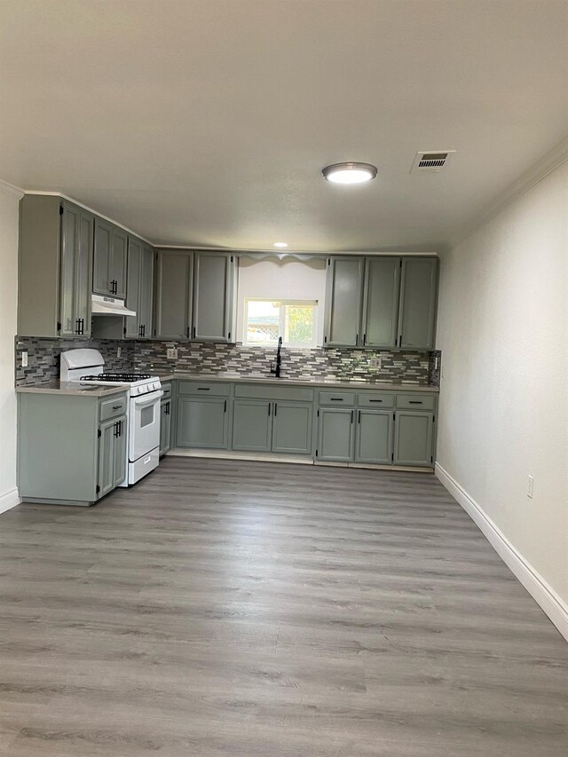 kitchen with white range, light hardwood / wood-style floors, and crown molding