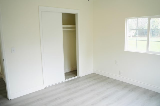 unfurnished bedroom featuring a closet and light wood-type flooring