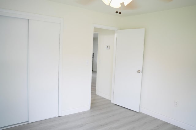 unfurnished bedroom with a closet and light wood-type flooring