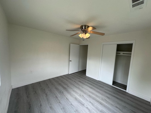 unfurnished bedroom featuring ceiling fan, wood-type flooring, and a closet