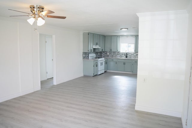 kitchen featuring tasteful backsplash, sink, ornamental molding, white gas range oven, and light hardwood / wood-style flooring