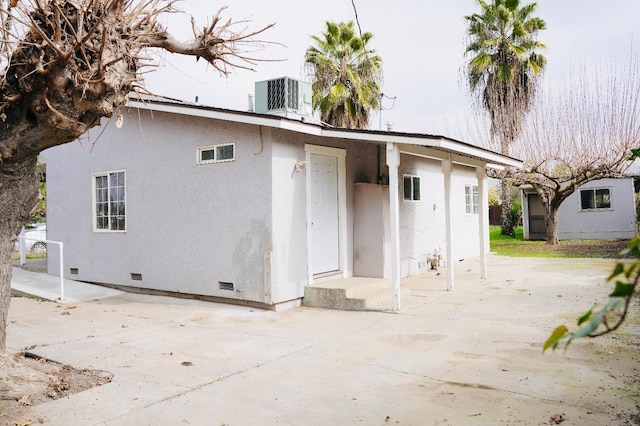 back of house with central AC unit and a patio