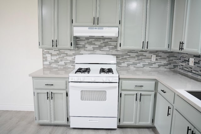 kitchen featuring backsplash, light hardwood / wood-style flooring, and gas range gas stove