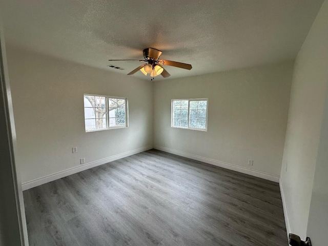 spare room with ceiling fan, a textured ceiling, and dark hardwood / wood-style flooring