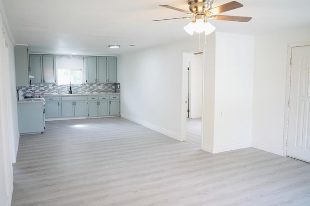 kitchen featuring tasteful backsplash, white gas range, sink, ceiling fan, and light hardwood / wood-style floors