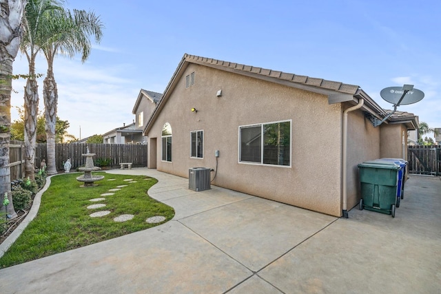 rear view of house featuring central AC, a patio area, and a yard