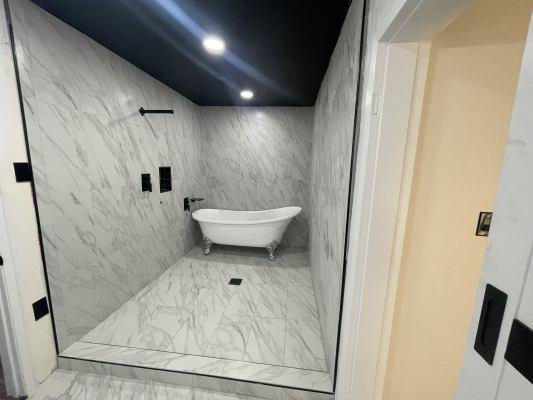 bathroom featuring tile walls and separate shower and tub