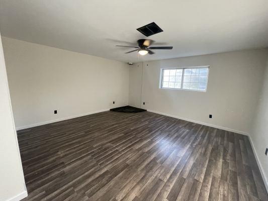 spare room with ceiling fan and dark wood-type flooring