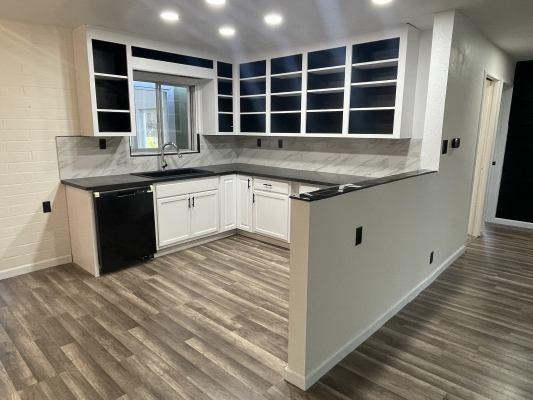 kitchen featuring dishwasher, sink, white cabinets, decorative backsplash, and dark hardwood / wood-style flooring