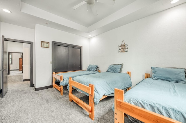 bedroom with a tray ceiling, ceiling fan, and light colored carpet