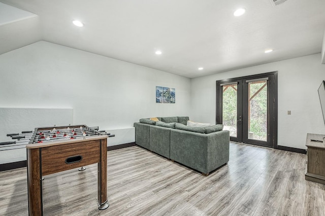 living room featuring french doors, light hardwood / wood-style flooring, and lofted ceiling