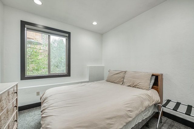 bedroom featuring lofted ceiling and dark colored carpet