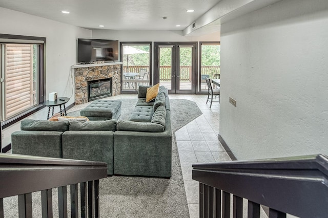 living room with french doors and a stone fireplace