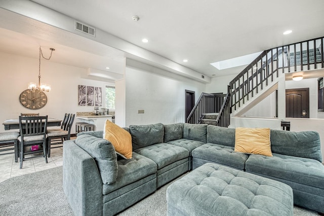 living room featuring a skylight, light colored carpet, and an inviting chandelier