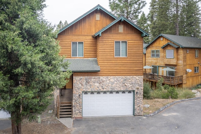 log-style house featuring a wooden deck and a garage