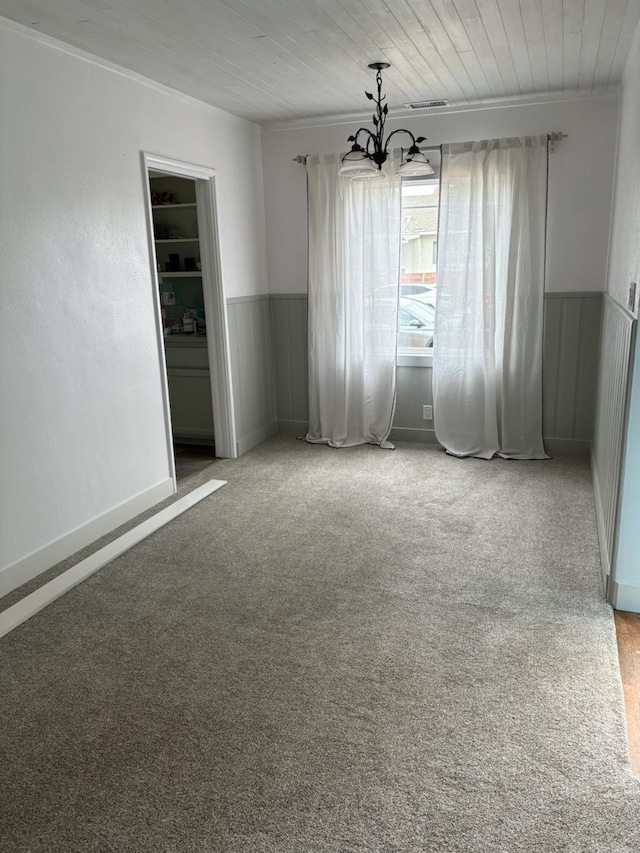 carpeted empty room with wooden ceiling and an inviting chandelier