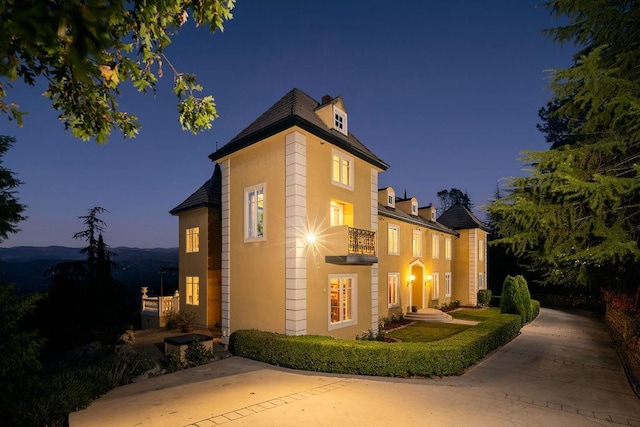 property exterior at dusk featuring a balcony