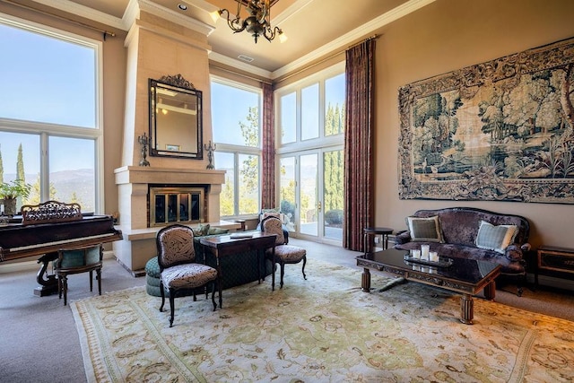 sitting room with carpet floors, a mountain view, a large fireplace, a towering ceiling, and ornamental molding