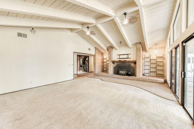 unfurnished living room featuring beamed ceiling, carpet, a wood stove, and high vaulted ceiling