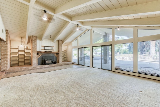 unfurnished living room featuring high vaulted ceiling, beamed ceiling, wood ceiling, a wood stove, and carpet