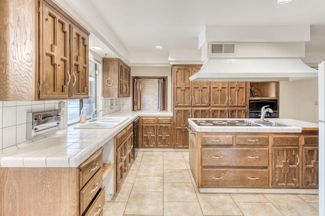 kitchen featuring white electric stovetop, tile countertops, sink, and tasteful backsplash