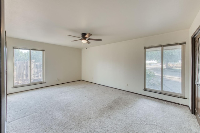 carpeted empty room featuring ceiling fan