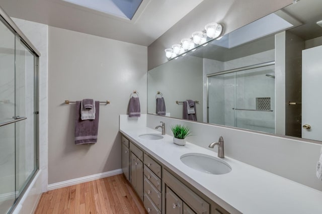 bathroom featuring vanity, combined bath / shower with glass door, and wood-type flooring