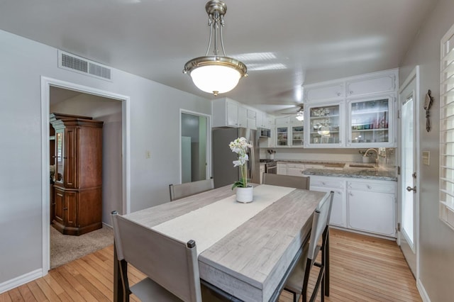 dining room with light hardwood / wood-style flooring, ceiling fan, and sink