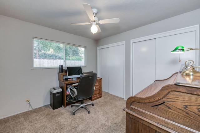 carpeted home office featuring ceiling fan