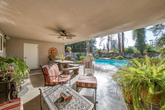 view of patio / terrace with a fenced in pool and ceiling fan