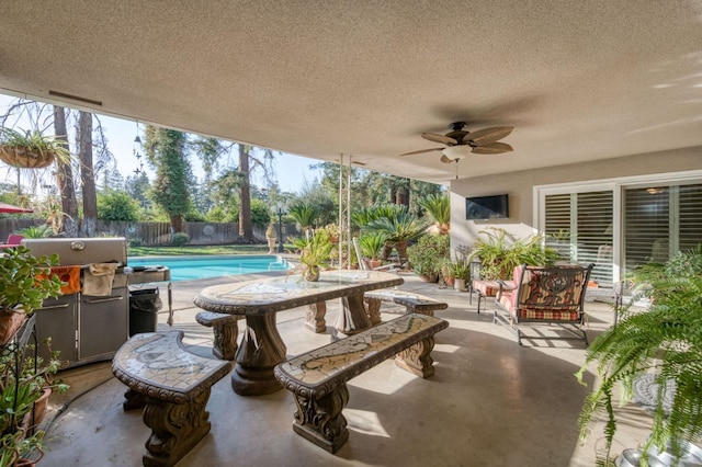 view of patio featuring a fenced in pool and ceiling fan