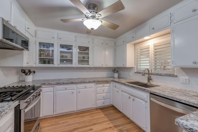 kitchen with stainless steel appliances, white cabinetry, and sink