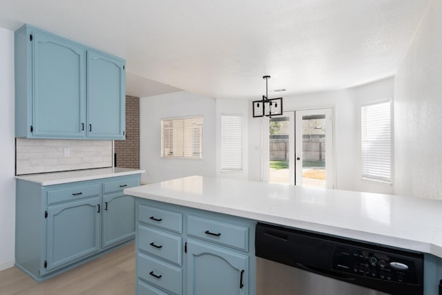 kitchen with hanging light fixtures, an inviting chandelier, light wood-type flooring, stainless steel dishwasher, and blue cabinets