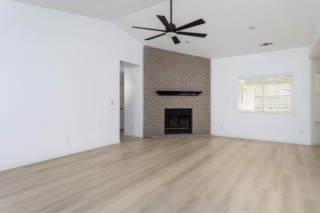 unfurnished living room featuring light hardwood / wood-style floors, vaulted ceiling, a fireplace, and ceiling fan