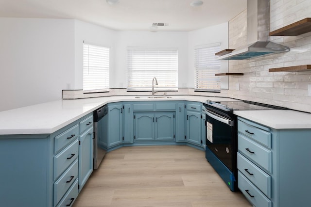 kitchen with dishwasher, wall chimney exhaust hood, sink, electric range, and blue cabinets