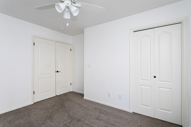 unfurnished bedroom with dark colored carpet and ceiling fan