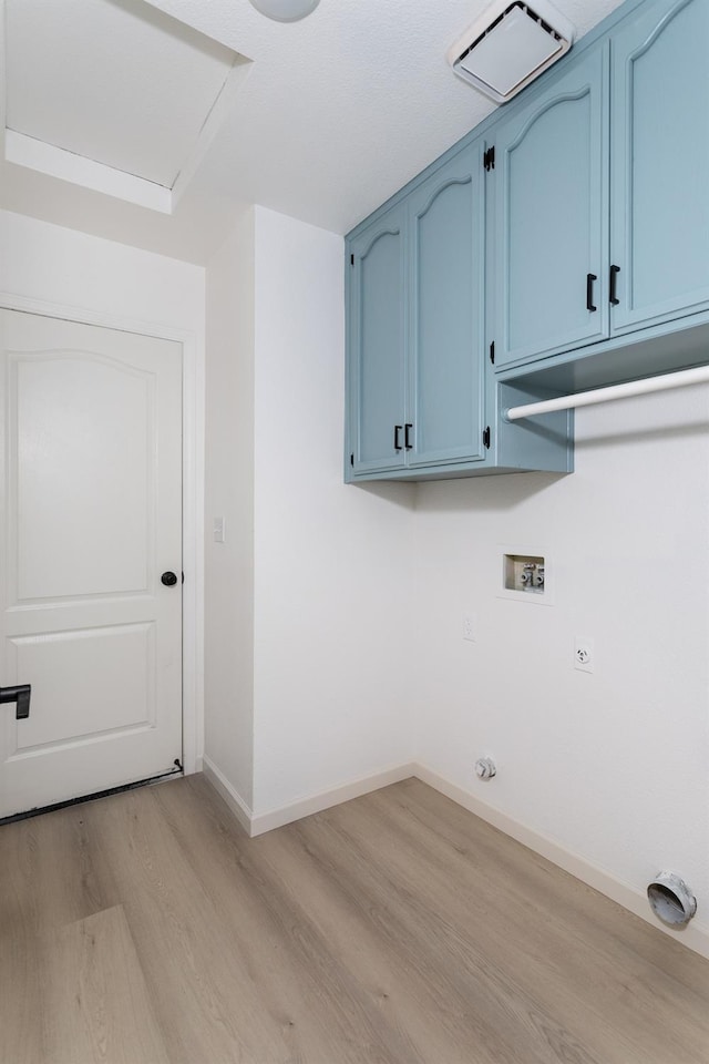 washroom with hookup for an electric dryer, light hardwood / wood-style floors, washer hookup, and cabinets