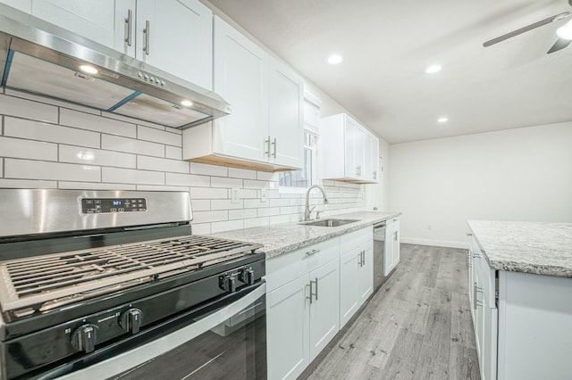 kitchen with white cabinets, sink, tasteful backsplash, appliances with stainless steel finishes, and light hardwood / wood-style floors