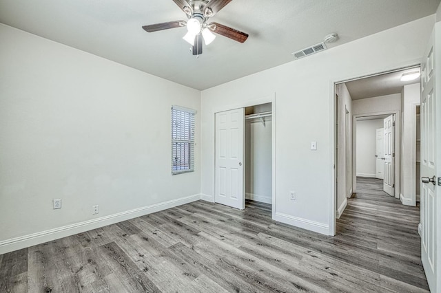 unfurnished bedroom featuring a closet, light wood-type flooring, and ceiling fan