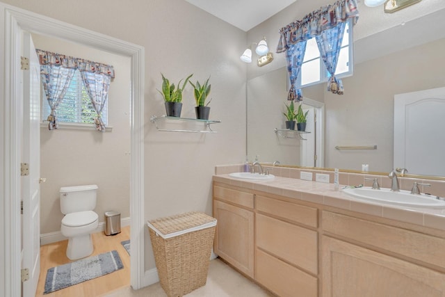 bathroom with vanity, toilet, and wood-type flooring