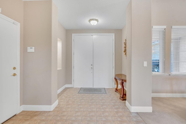 carpeted entrance foyer with a textured ceiling